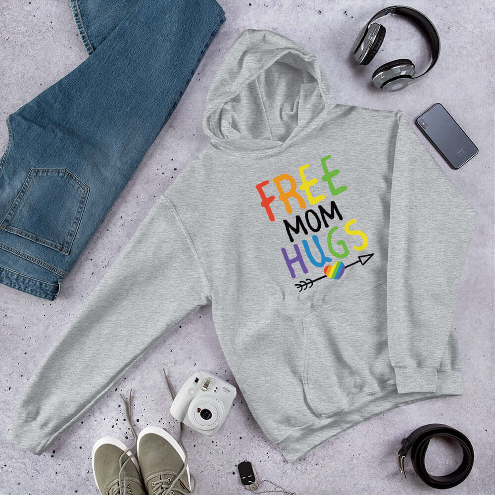 Light grey hooded sweatshirt with the words Free Mom hugs in rainbow lettering printed on the front.