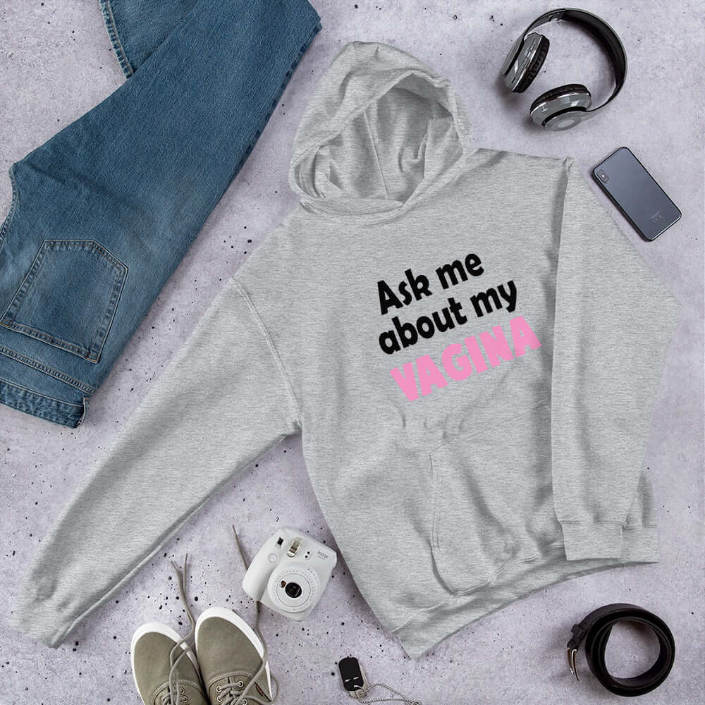 Sport grey hoodie sweatshirt with the words Ask me about my vagina printed on the front. The word vagina is printed in pink. The rest of the text is black.