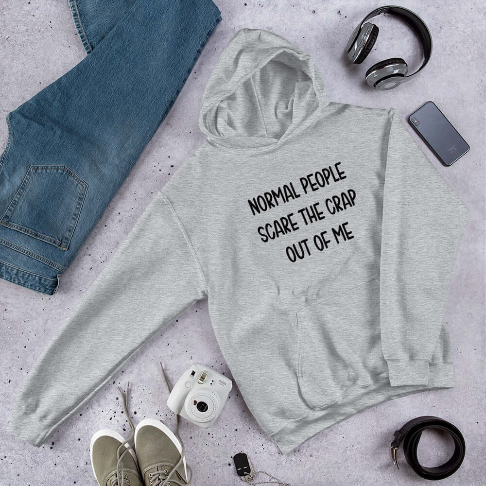 Light grey hoodie sweatshirt with the phrase Normal people scare the crap out of me printed on the front.