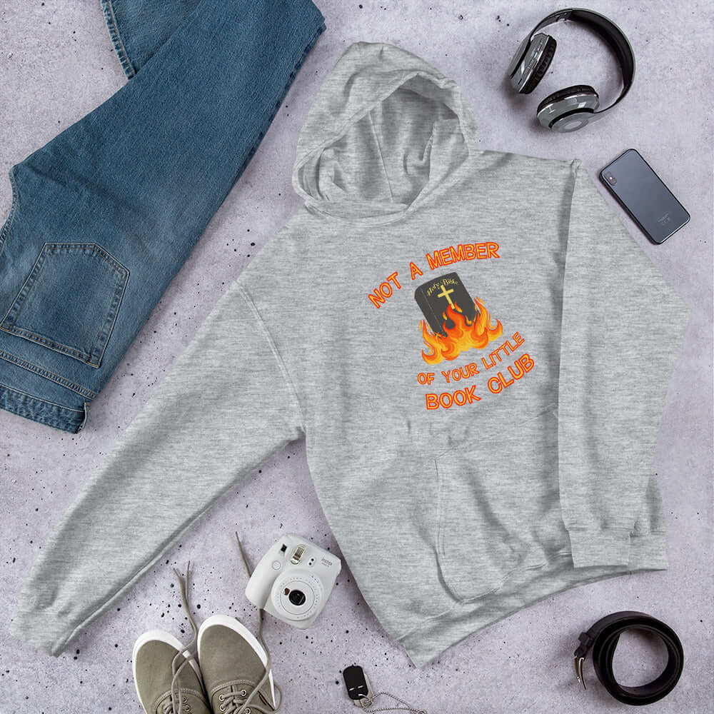 Light grey hoodie sweatshirt with image of a burning bible and the words Not a member of your little book club printed on the front.