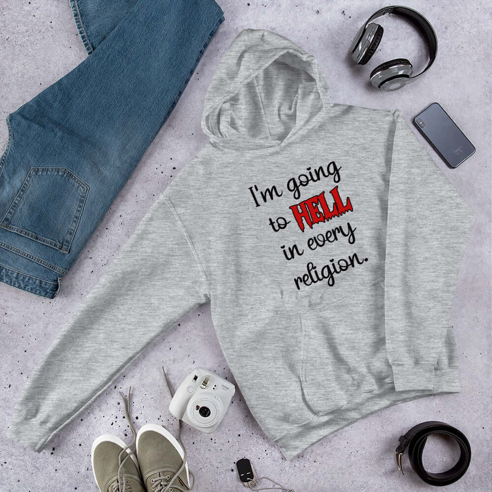 Light grey hoodie sweatshirt with the phrase I'm going to hell in every religion printed on the front. The word hell is printed in red. The rest of the text is black.