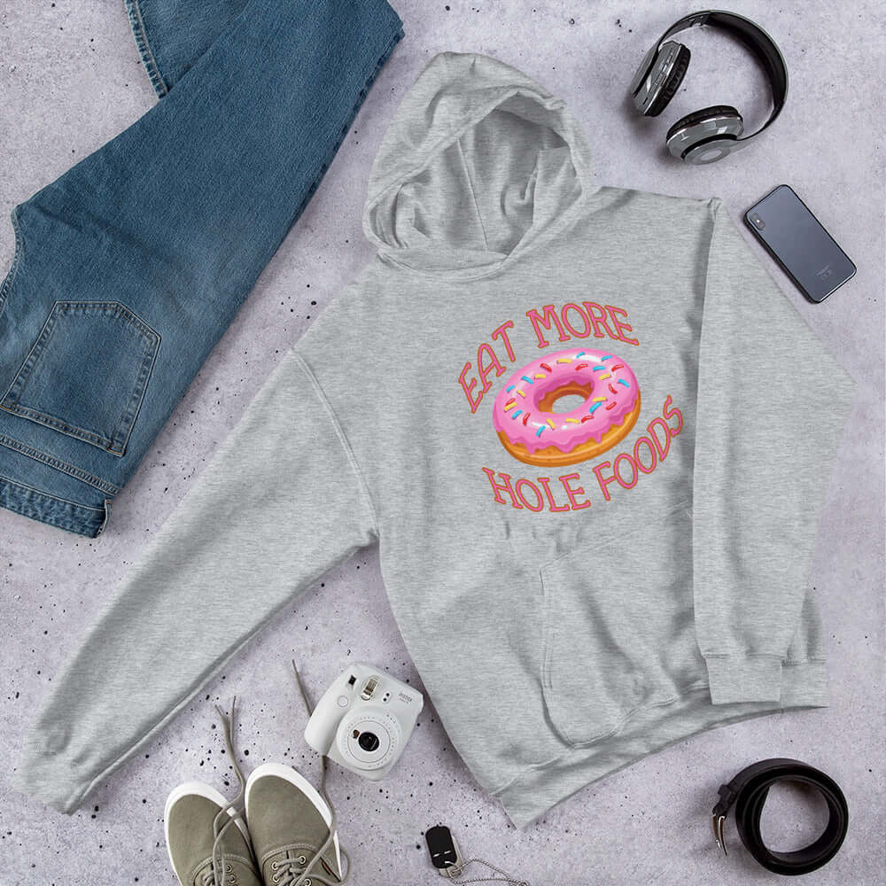 Sport grey hoodie sweatshirt with an image of a donut with pink icing and sprinkles and the words Eat more hole foods printed on the front.