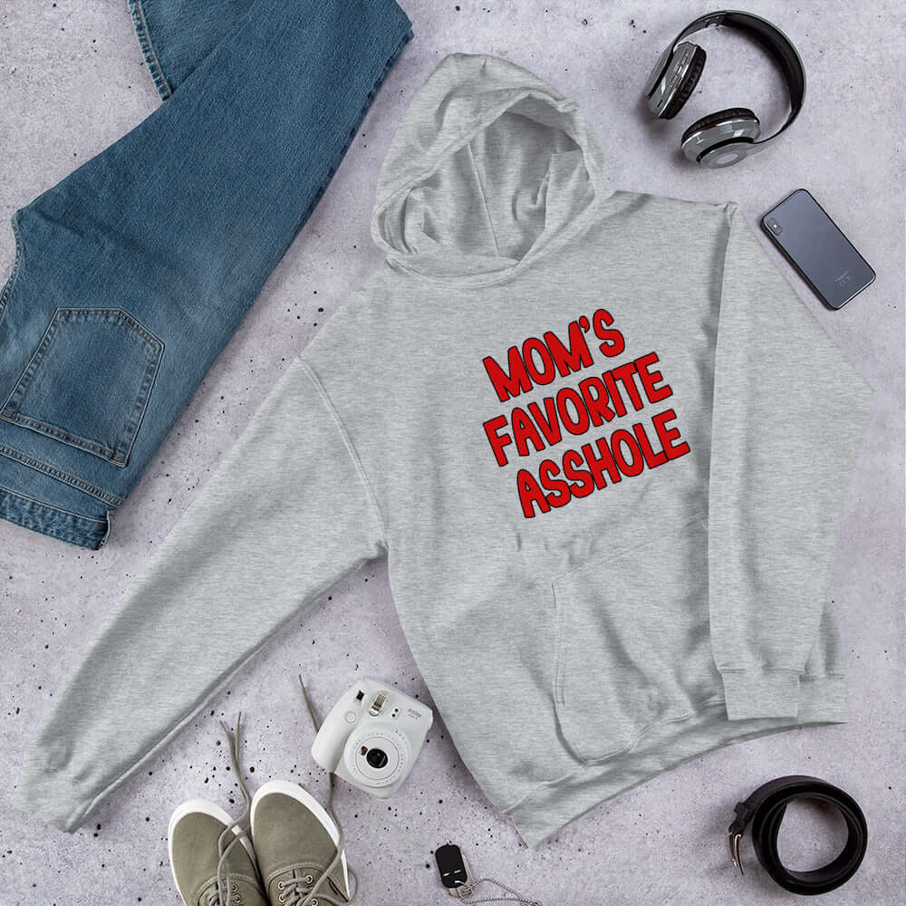 Light grey hooded sweatshirt with the words Mom's favorite asshole printed in red on the front. 