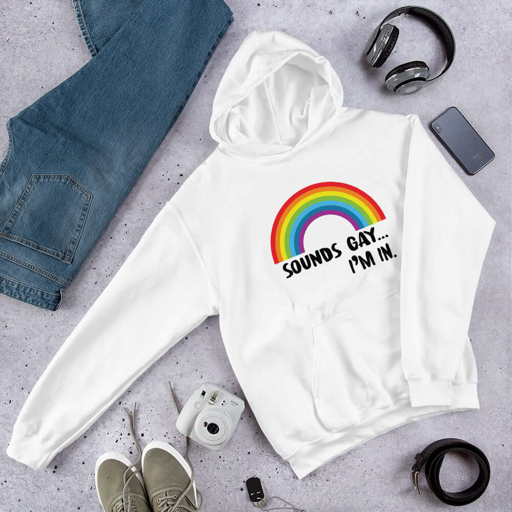 White hoodie sweatshirt that has an image of a rainbow and the phrase Sounds gay, I'm in printed on the front