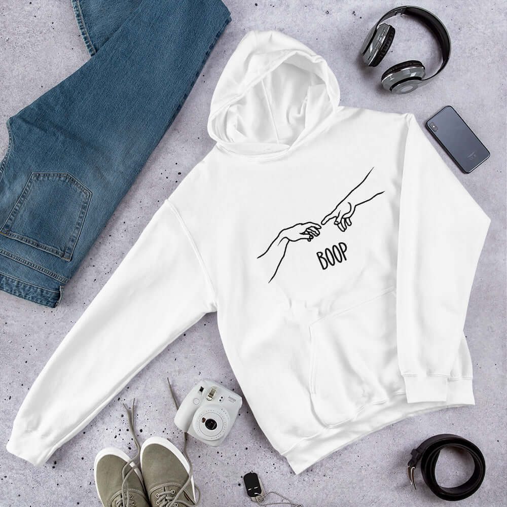 White hoodie sweatshirt with line drawing hands reaching out and touching in the center like they in the famous art creation of Adam. The word Boop is printed underneath.