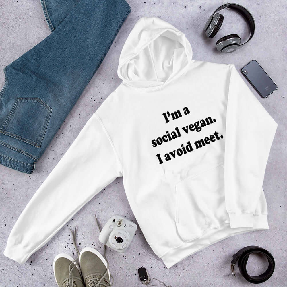 White hoodie sweatshirt with the pun phrase I'm a social vegan, I avoid meet printed on the front.
