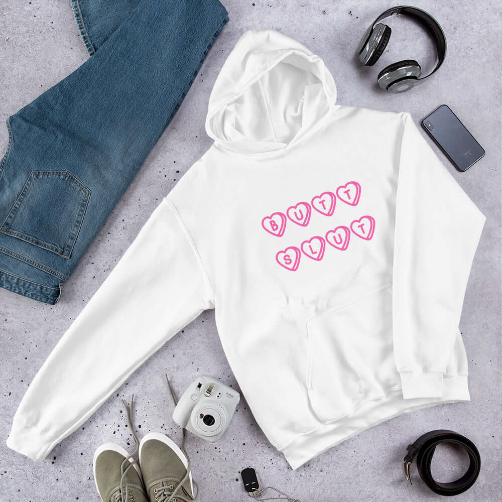 White hoodie sweatshirt with the words Butt Slut printed in pink on the front. Pink hearts are around each letter in the text.