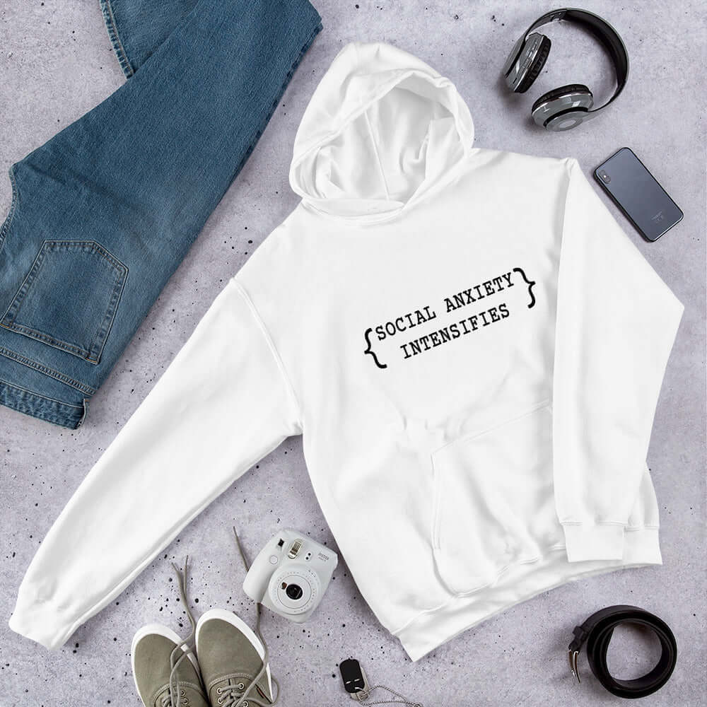 White hoodie sweatshirt with the words Social anxiety intensifies printed on the front.