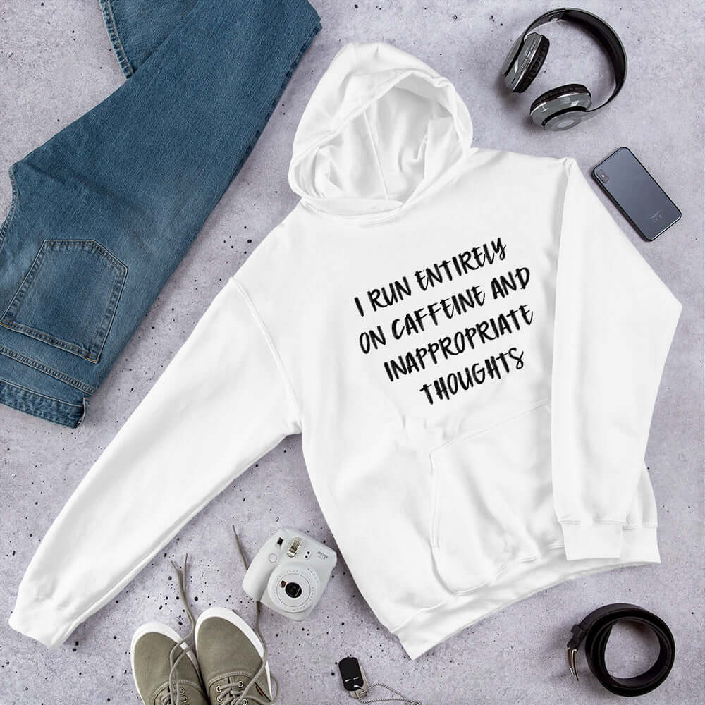 White hoodie sweatshirt with the words I run entirely on caffeine & inappropriate thoughts printed on the front.