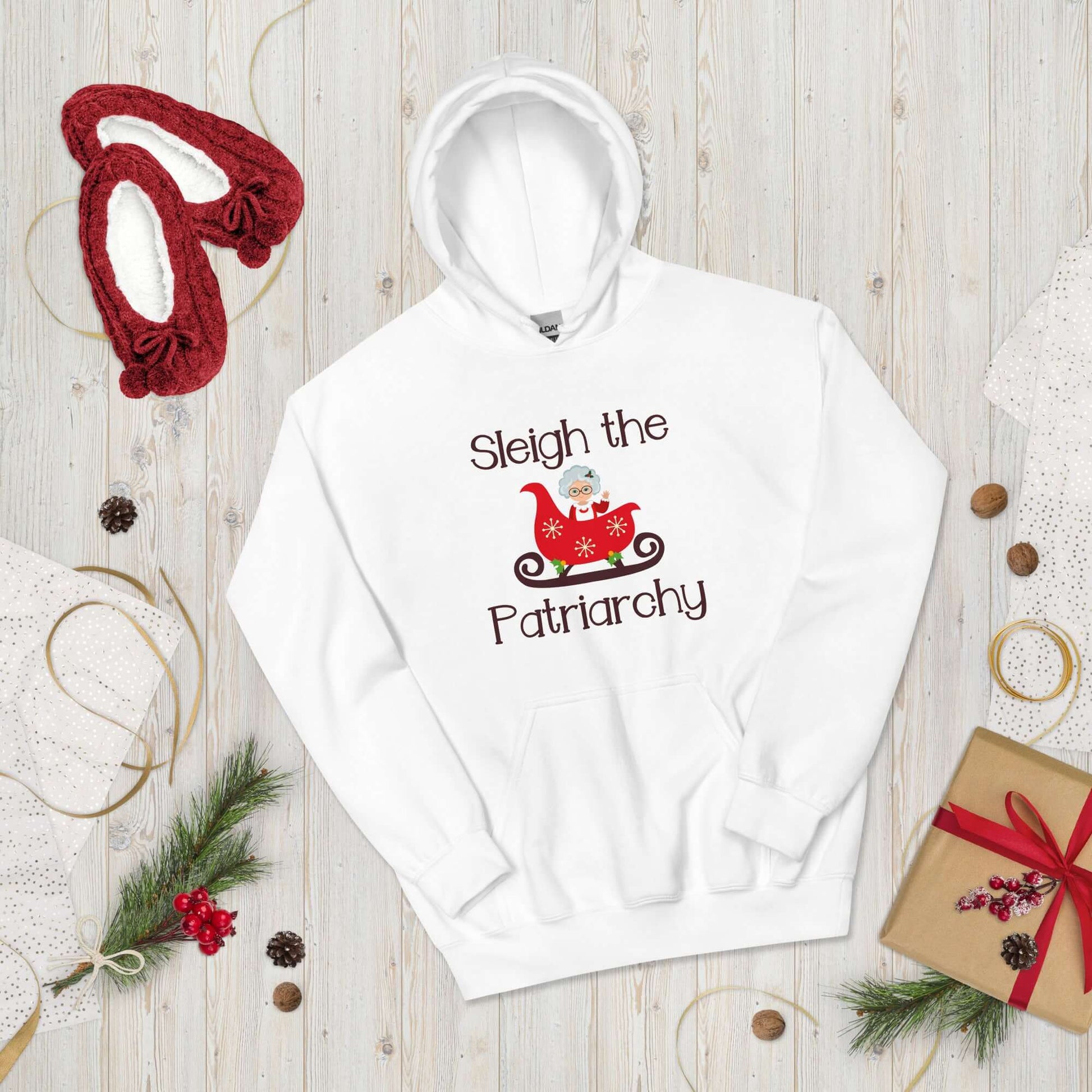 White hooded sweatshirt with graphic of Mrs. Claus sitting in a sleigh and the words Sleigh the patriarchy printed on the front.