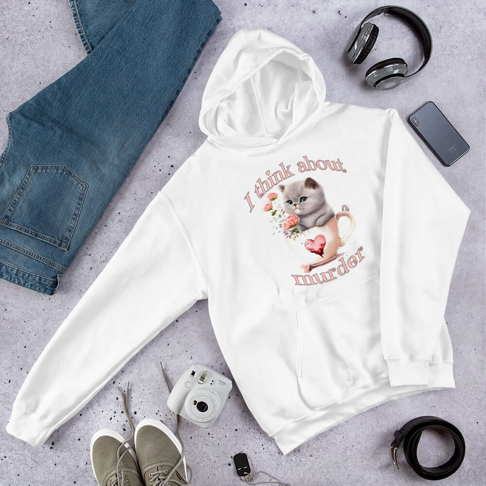 White hooded sweatshirt that says I think about murder with image of cute fluffy kitten sitting in a teacup printed on the front.