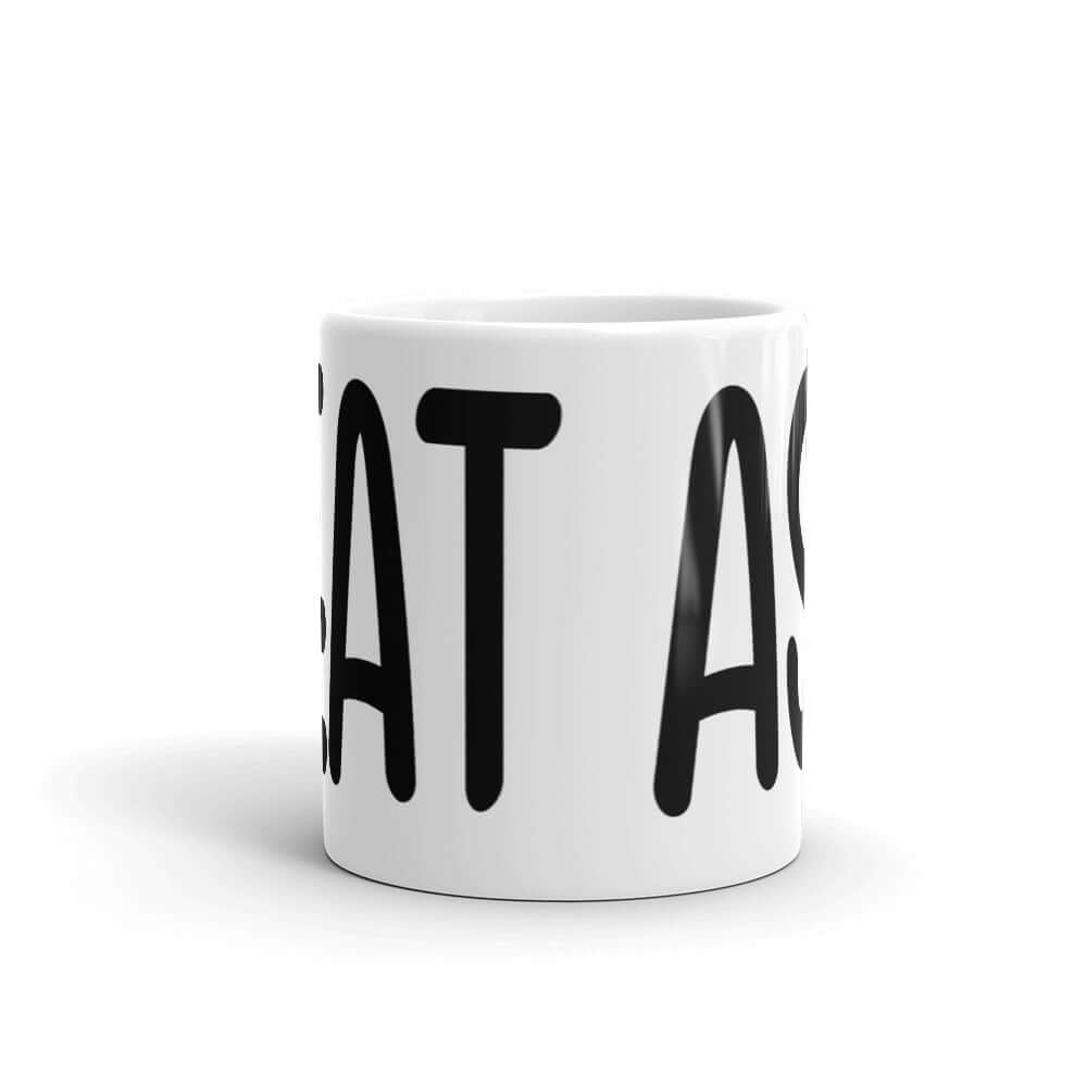 White ceramic coffee mug with the words I eat ass printed on it. The words are large and wrap all around the mug.