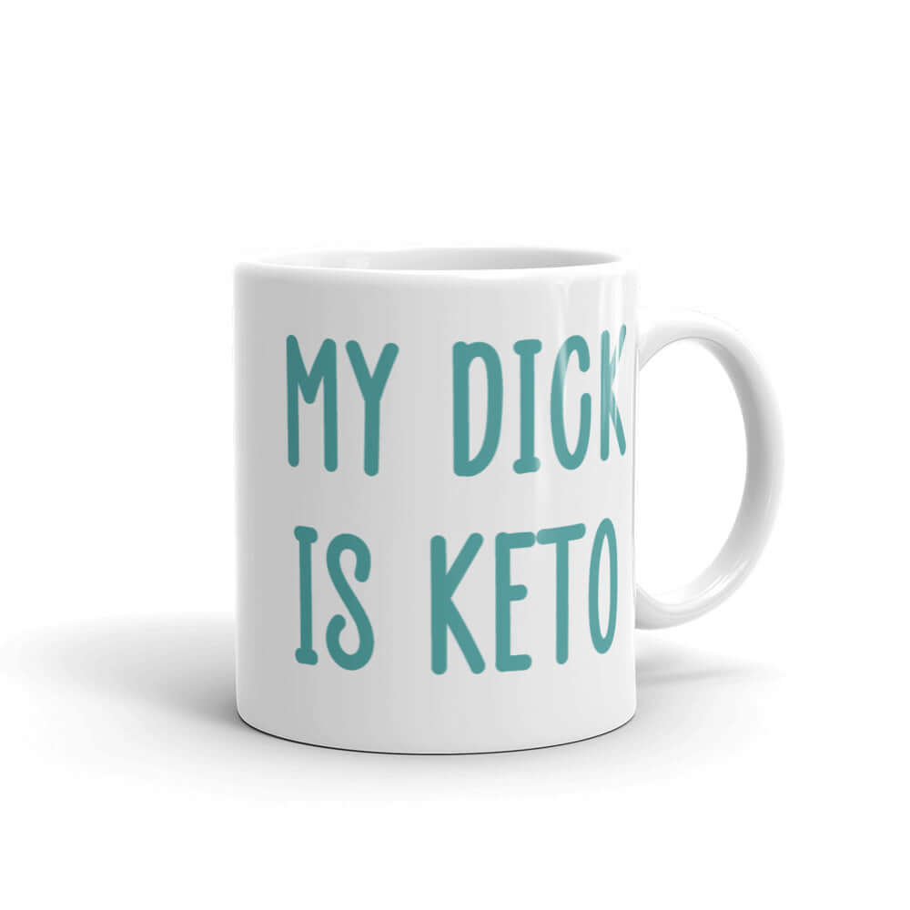 White ceramic coffee mug with the phrase My dick is keto printed on both sides in turquoise font.