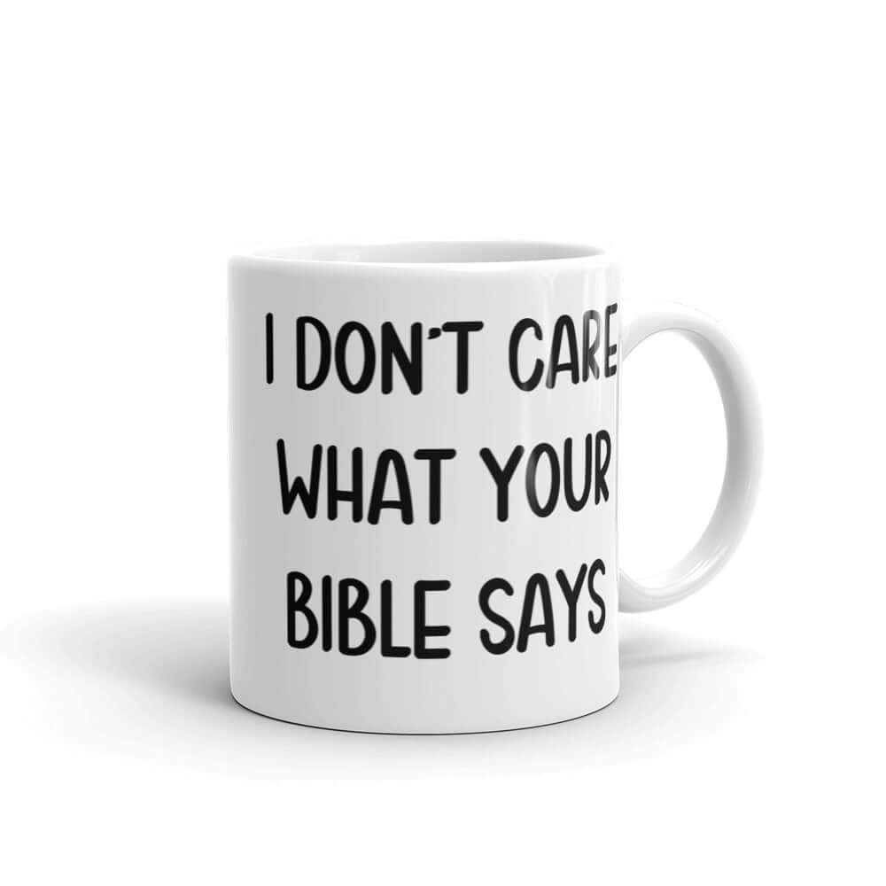 White ceramic mug with the words I don't care what your bible says printed on both sides.