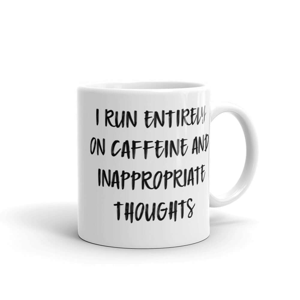 White ceramic coffee mug with the words I run entirely on caffeine & inappropriate thoughts printed on both sides.