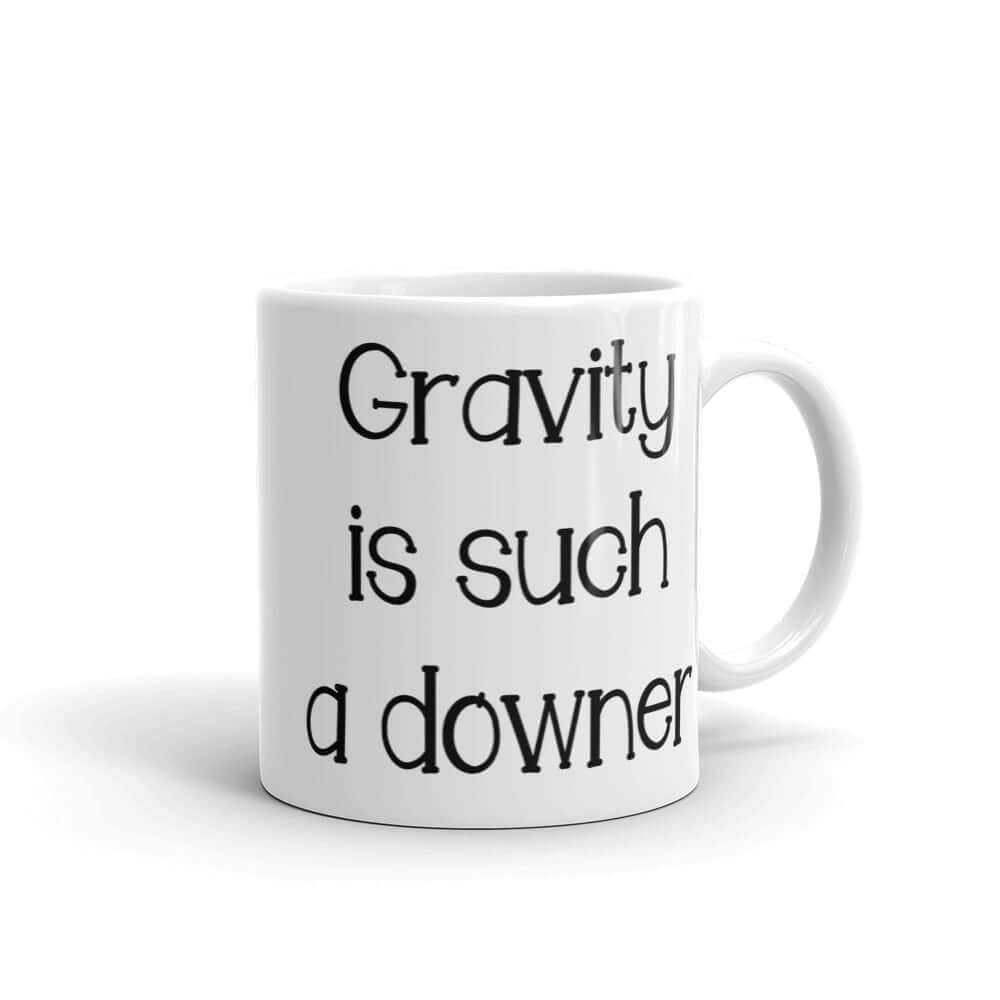 White ceramic coffee mug with the words Gravity is such a downer printed on both sides.