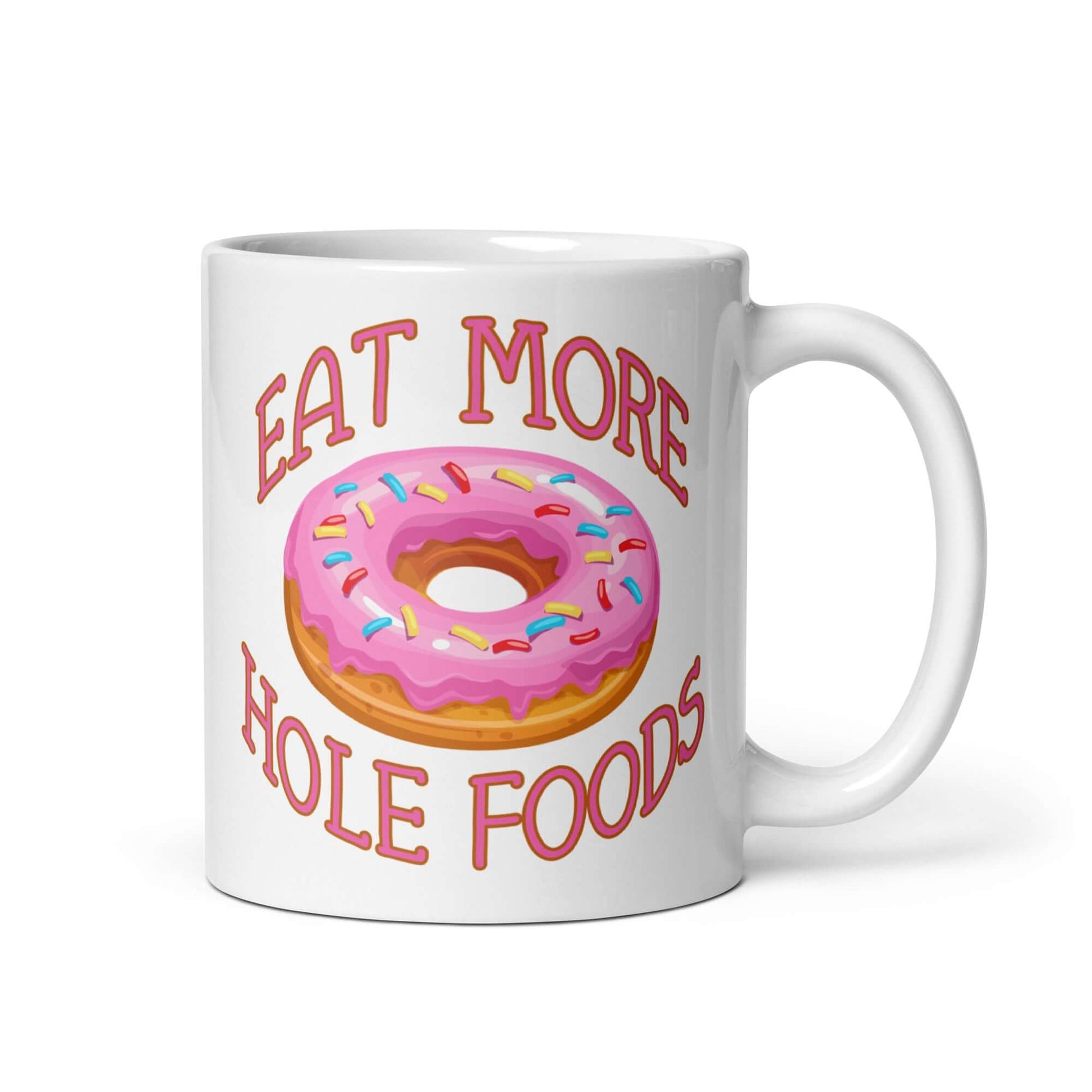 White coffee mug with an image of a donut with pink icing and sprinkles and the words Eat more hole foods printed on both sides.