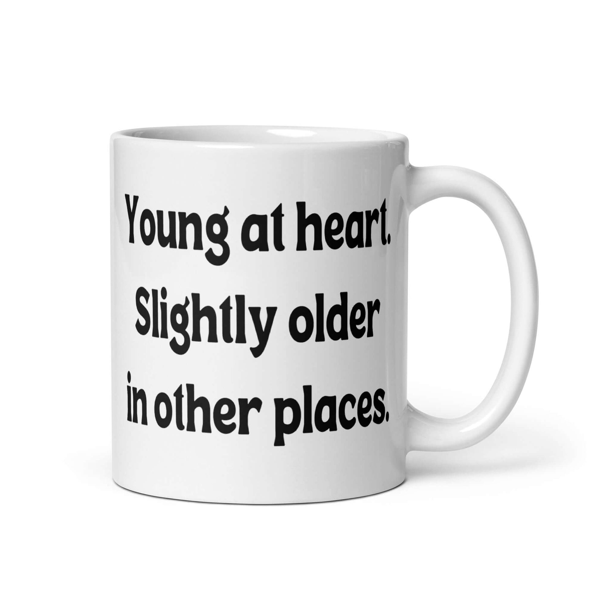 White ceramic mug with the words Young at heart, slightly older in other places printed on both sides.