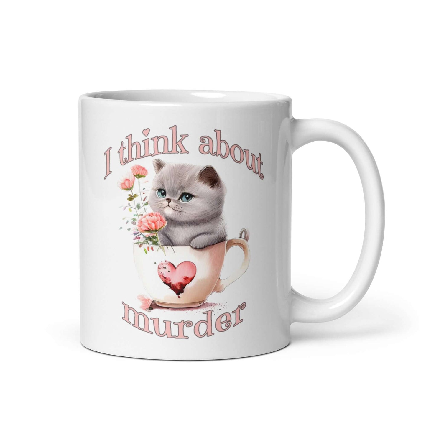 White ceramic mug that says I think about murder with image of cute fluffy kitten sitting in a teacup printed on both sides.