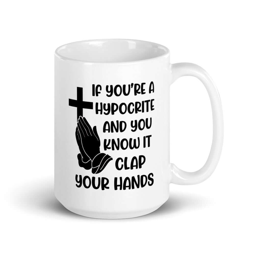 White ceramic mug with image of a cross and praying hands & the words If you're a hypocrite and you know it clap your hands printed on both sides.