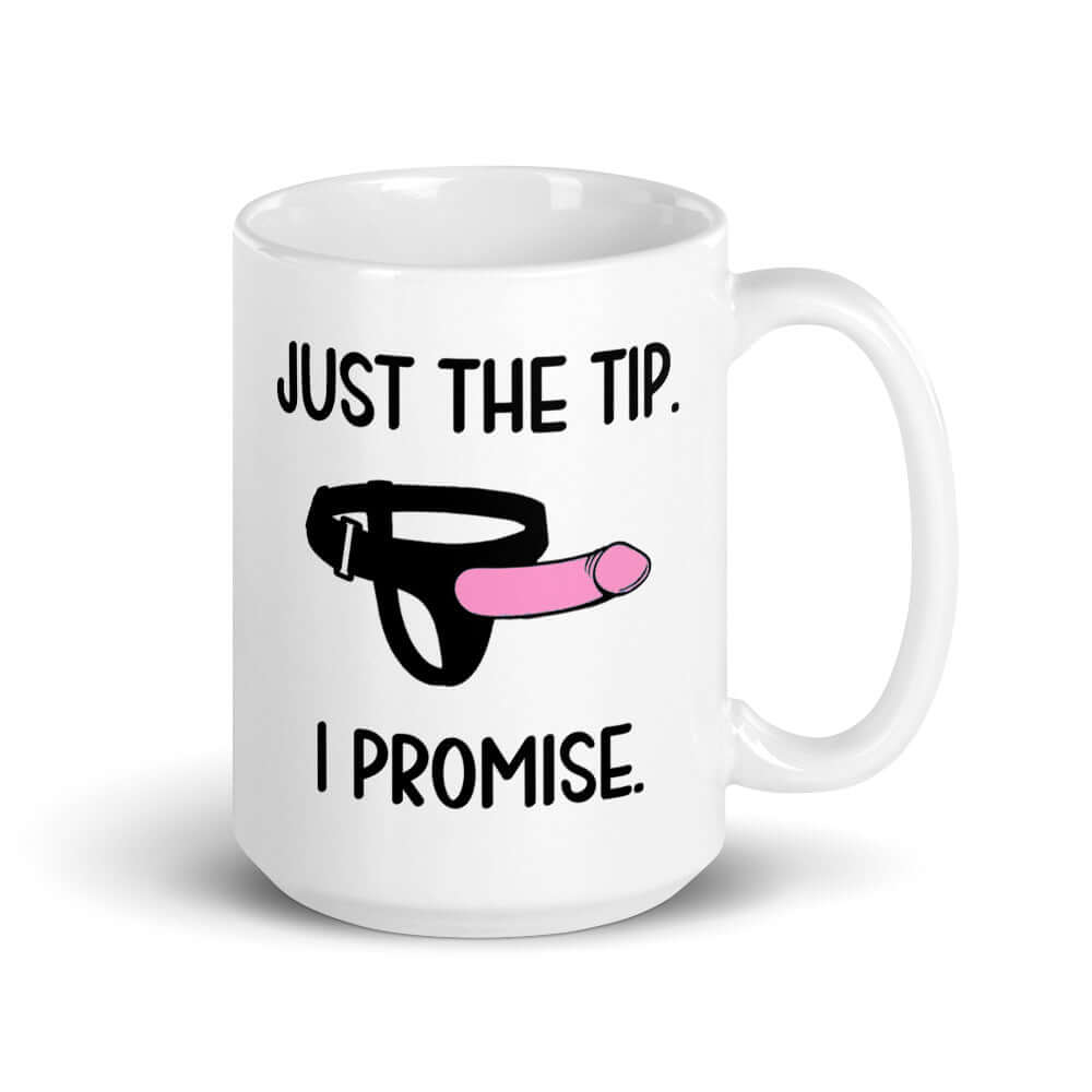 White ceramic coffee mug that has an image of a strap-on dildo and the words Just the tip, I promise printed on both sides. The graphics are pink, black and white.