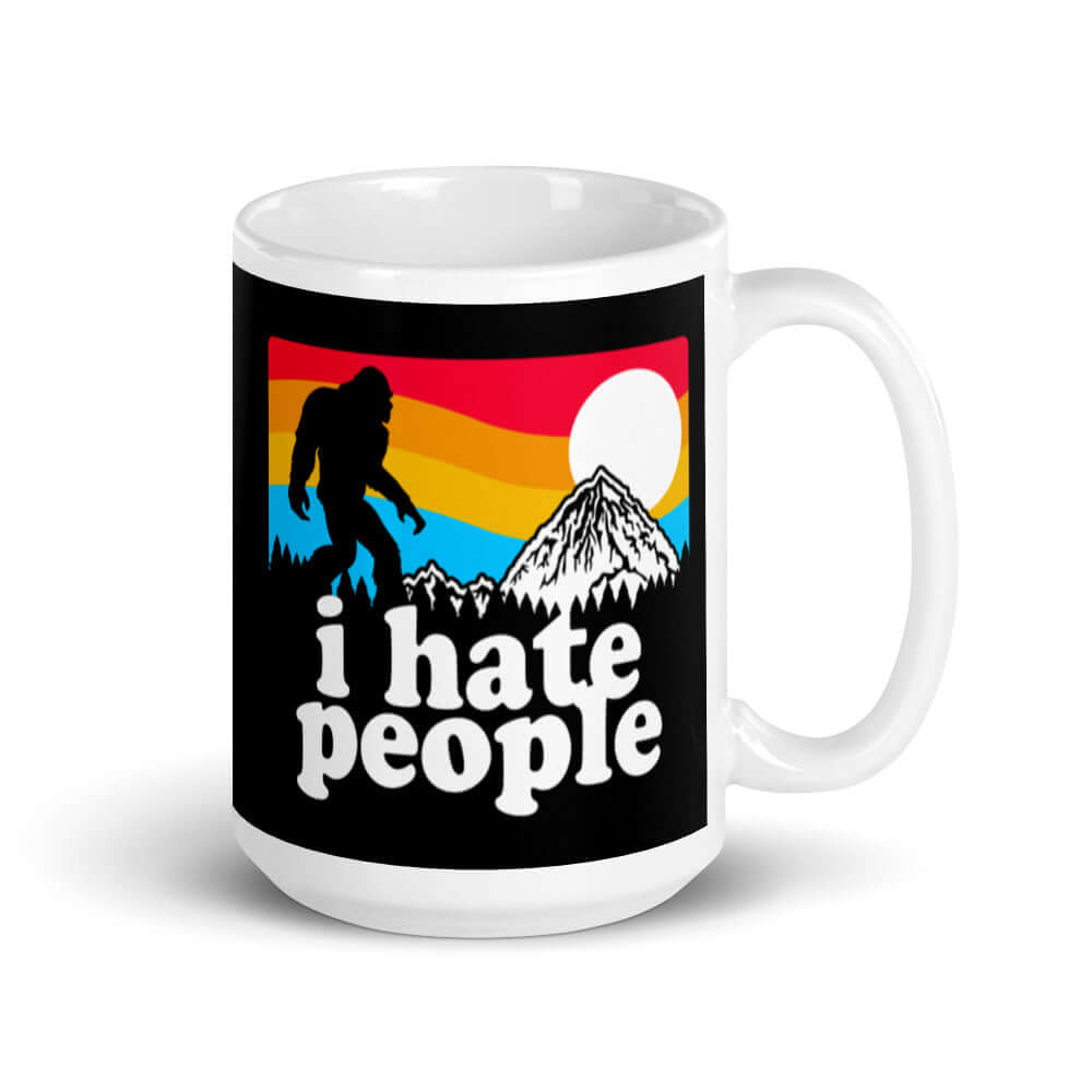 White coffee mug with graphic of Bigfoot walking into the sunset with the words I hate people printed on both sides. 