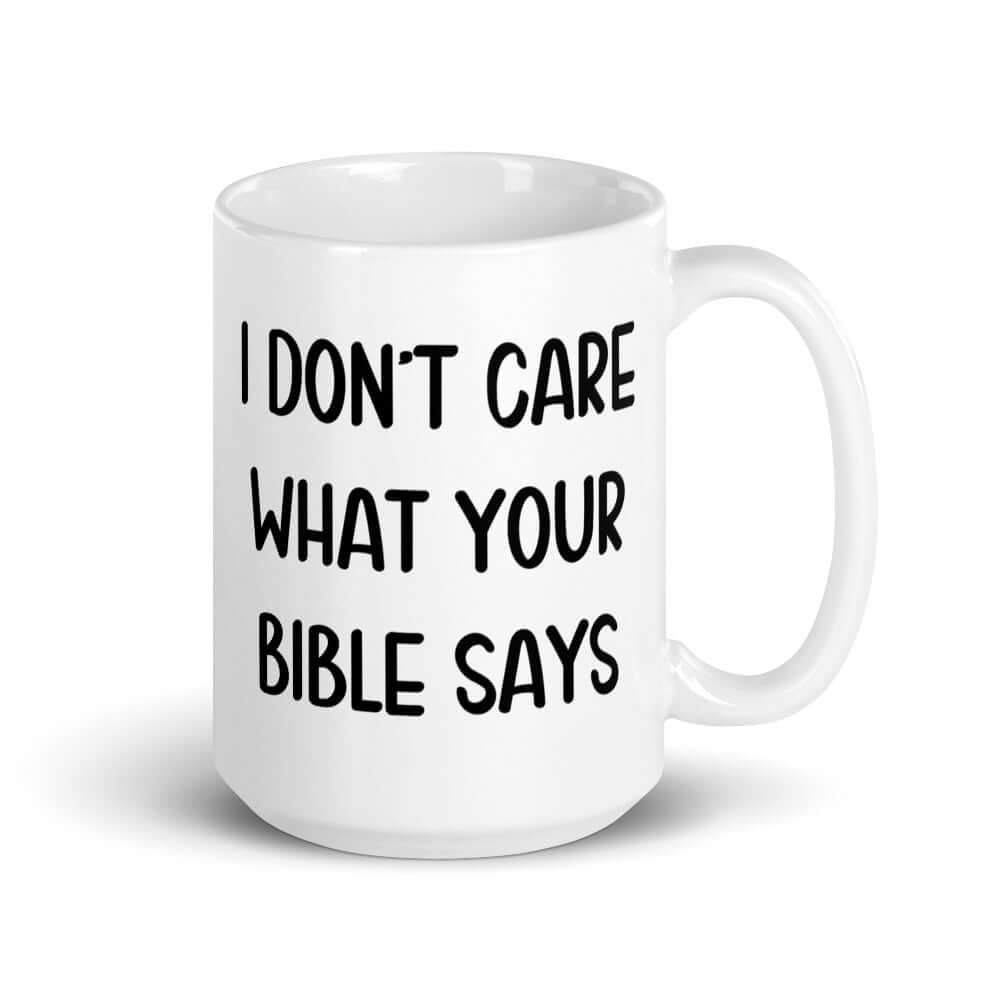 White ceramic mug with the words I don't care what your bible says printed on both sides.