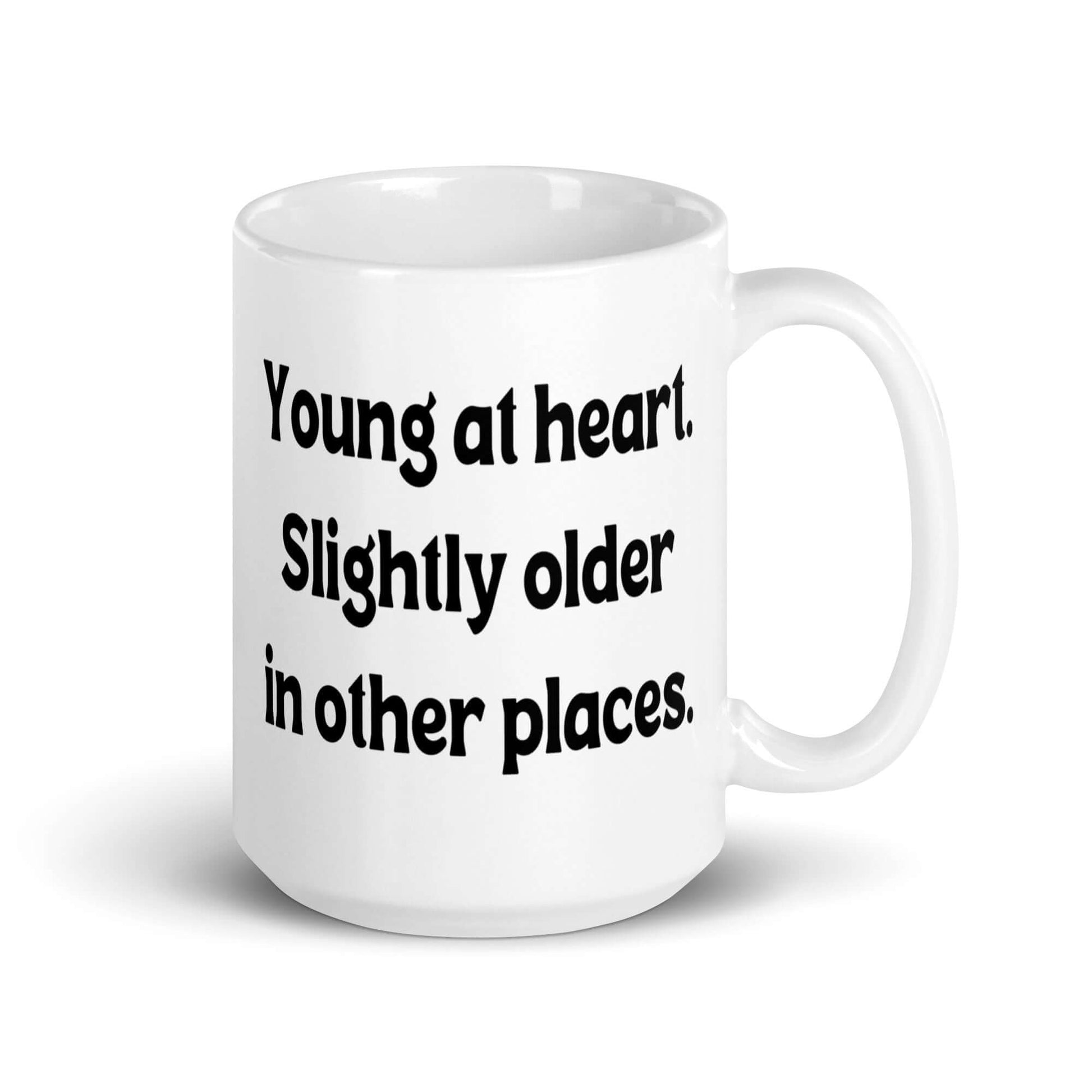 White ceramic mug with the words Young at heart, slightly older in other places printed on both sides.