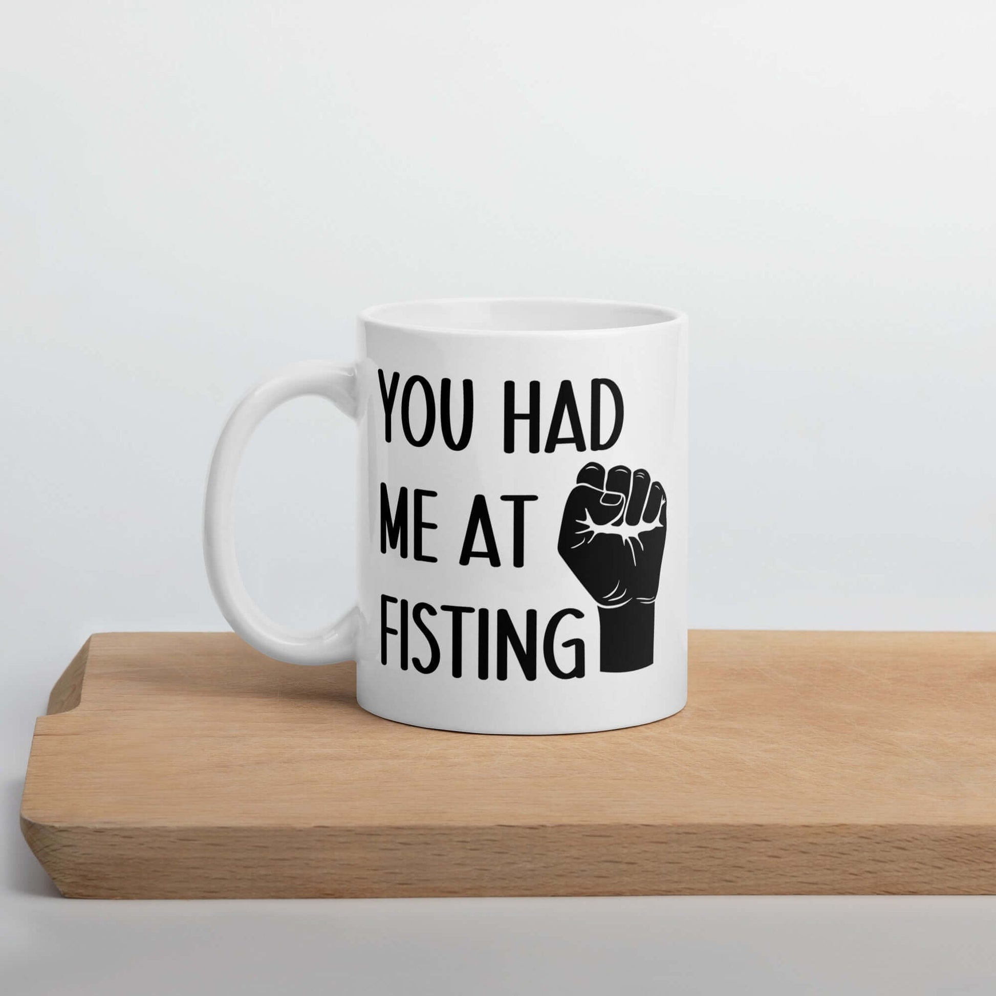 White ceramic mug with image of a fist and the words You had me at fisting printed on both sides.