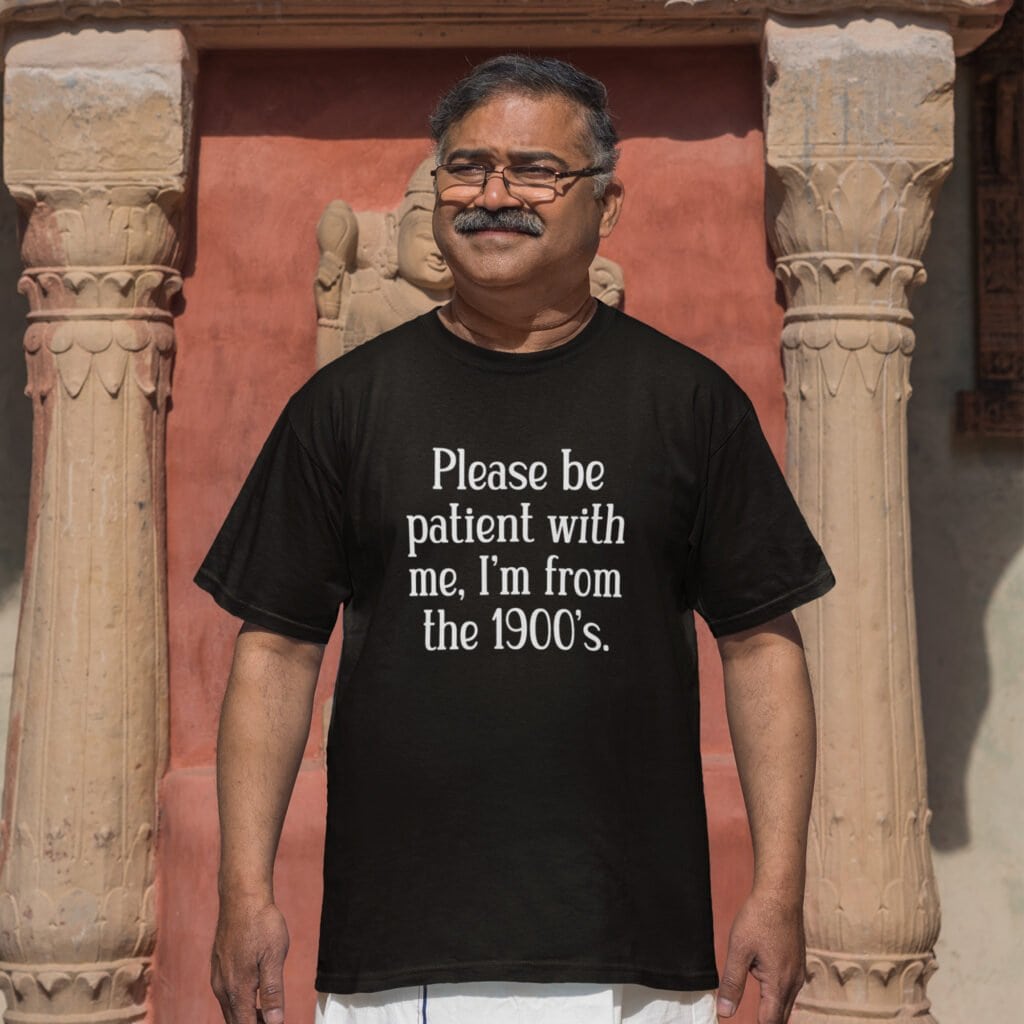 Man wearing a black t-shirt with the text 'Please be patient with me, I'm from the 1900's' printed on the front.