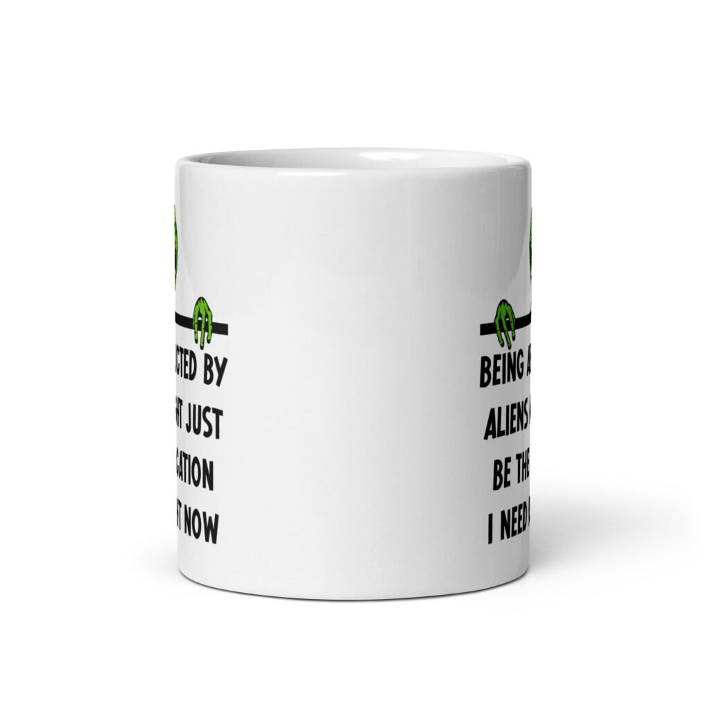 White ceramic mug with image of an alien and the words 'Being abducted by aliens might just be the vacation I need right now' printed on both sides.