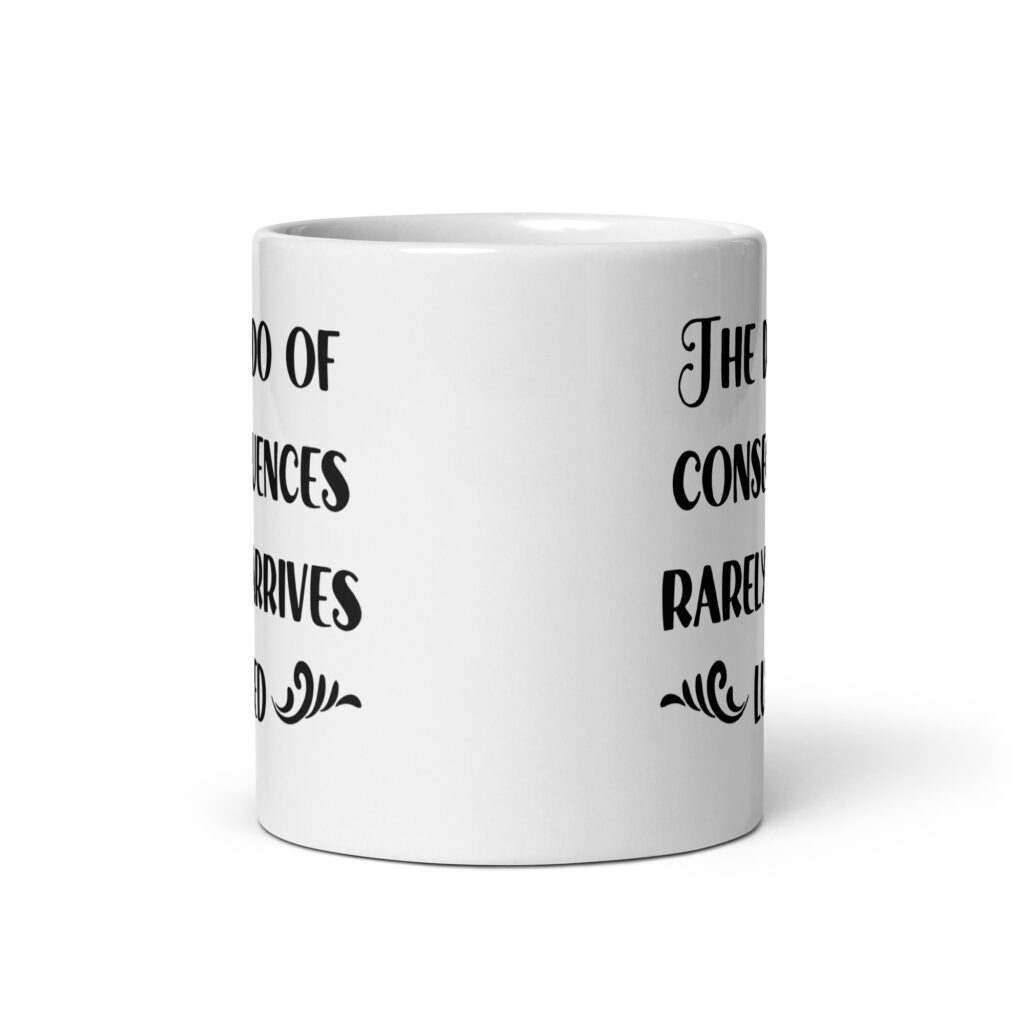 White ceramic mug with the text 'The dildo of consequences rarely arrives lubed' printed on both sides.