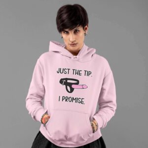 Alternative looking woman with short hair wearing a light pink hoodie sweatshirt. The hoodie has an image of a strap-on dildo and the words 'Just the tip. I promise.' printed on the front.