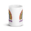 White ceramic mug with an image of a boho style rainbow. There is an upside down cross in the center arch of the rainbow and the text 'Love like Lucifer' printed under. The graphics are printed on both sides of the mug.