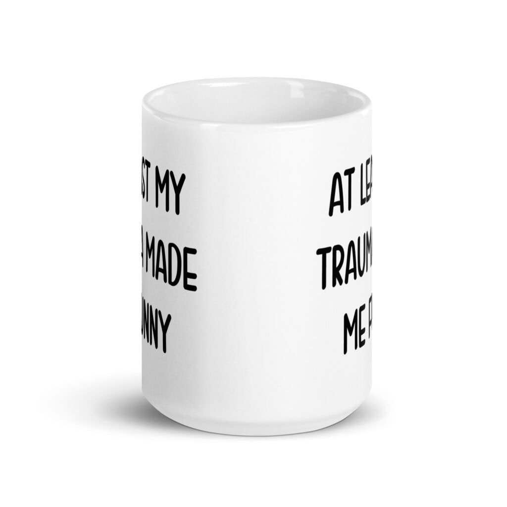 White ceramic mug with the text 'At least my trauma made me funny' printed on both sides.