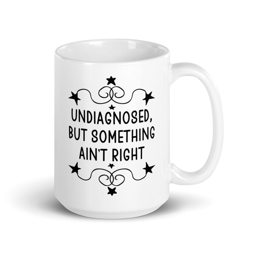 White ceramic mug with the text 'Undiagnosed, but something ain't right' printed on both sides.