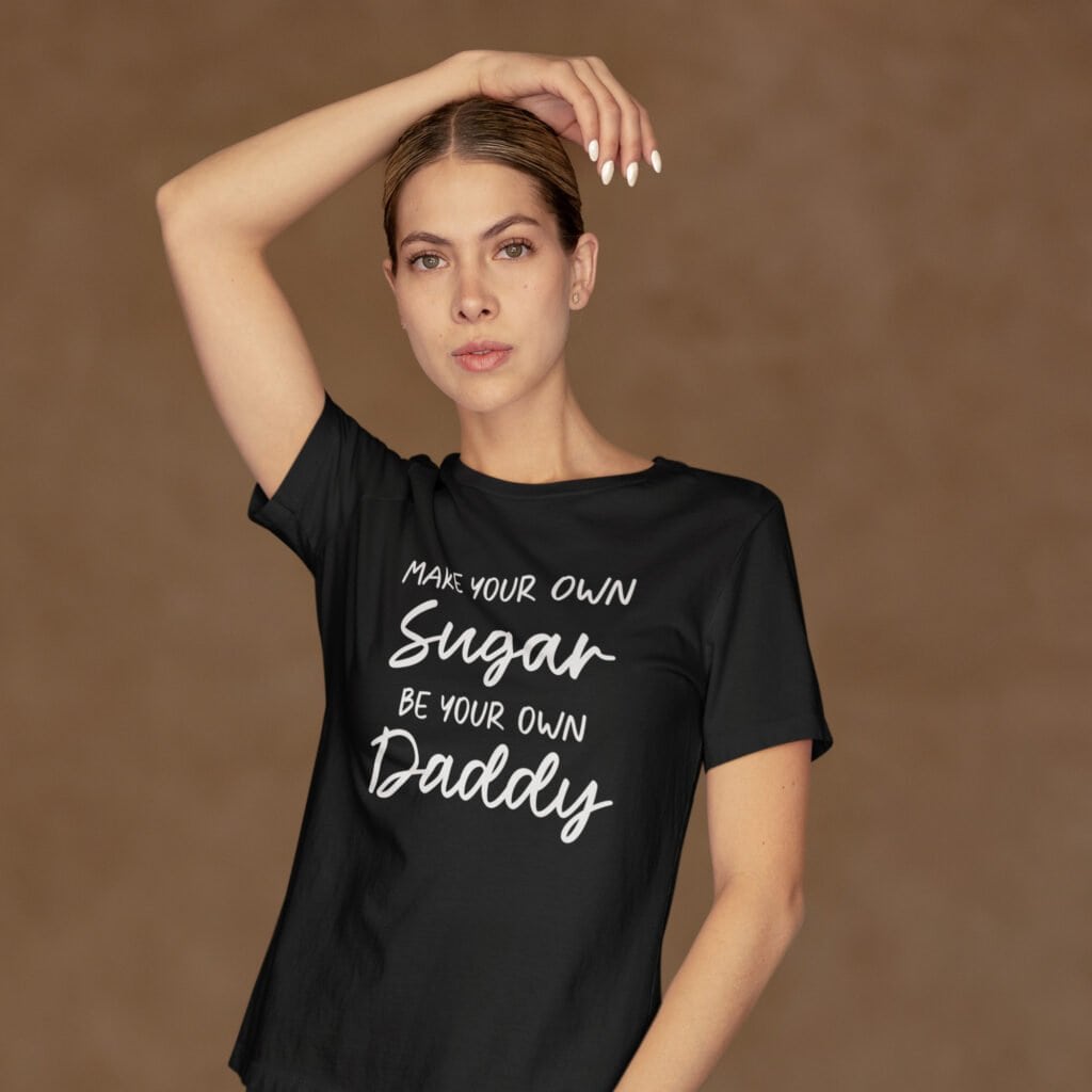 Woman wearing a black t-shirt with the text 'Make your own sugar Be your own Daddy' printed on the front.