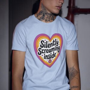 Man wearing a light blue t-shirt with a colorful graphic that says 'Silently screaming inside'. The graphics are printed on the front.