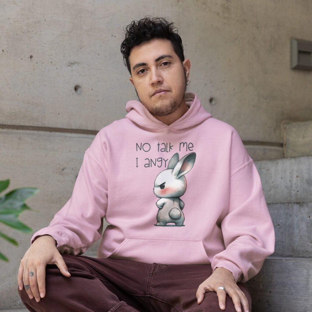 Man wearing a light pink hoodie sweatshirt with an image of an angry bunny and the text 'No talk me I angy' printed on the front.