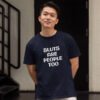 Man wearing a navy blue t-shirt with the text 'Sluts are people too' printed on the front.