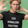 Man wearing a black t-shirt with the text 'Stop normalizing everything' printed on the front.