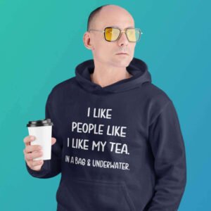 Serious looking man holding cup of tea. He is wearing a navy blue hoodie sweatshirt with the text 'I like people like I like my tea. In a bag & underwater.' printed on the front.