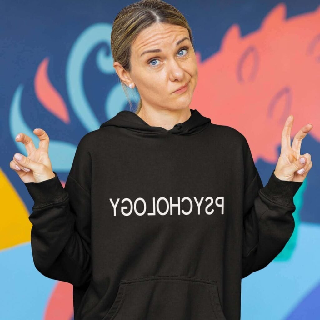 Woman wearing funny black hoodie sweatshirt with the word Psychology printed in reverse on the front.