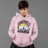Edgy woman wearing a pink hoodie sweatshirt. The hoodie has a graphic of a kawaii style unicorn and a pastel rainbow with the text 'Everything is fucked' printed on the front.