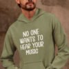 Man wearing a military green hoodie sweatshirt with the text 'No one wants to hear your music' printed on the front.