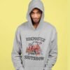 Man wearing a light grey hoodie sweatshirt with a circus theme graphic and the text 'Ringmaster of the Shitshow' printed on the front.