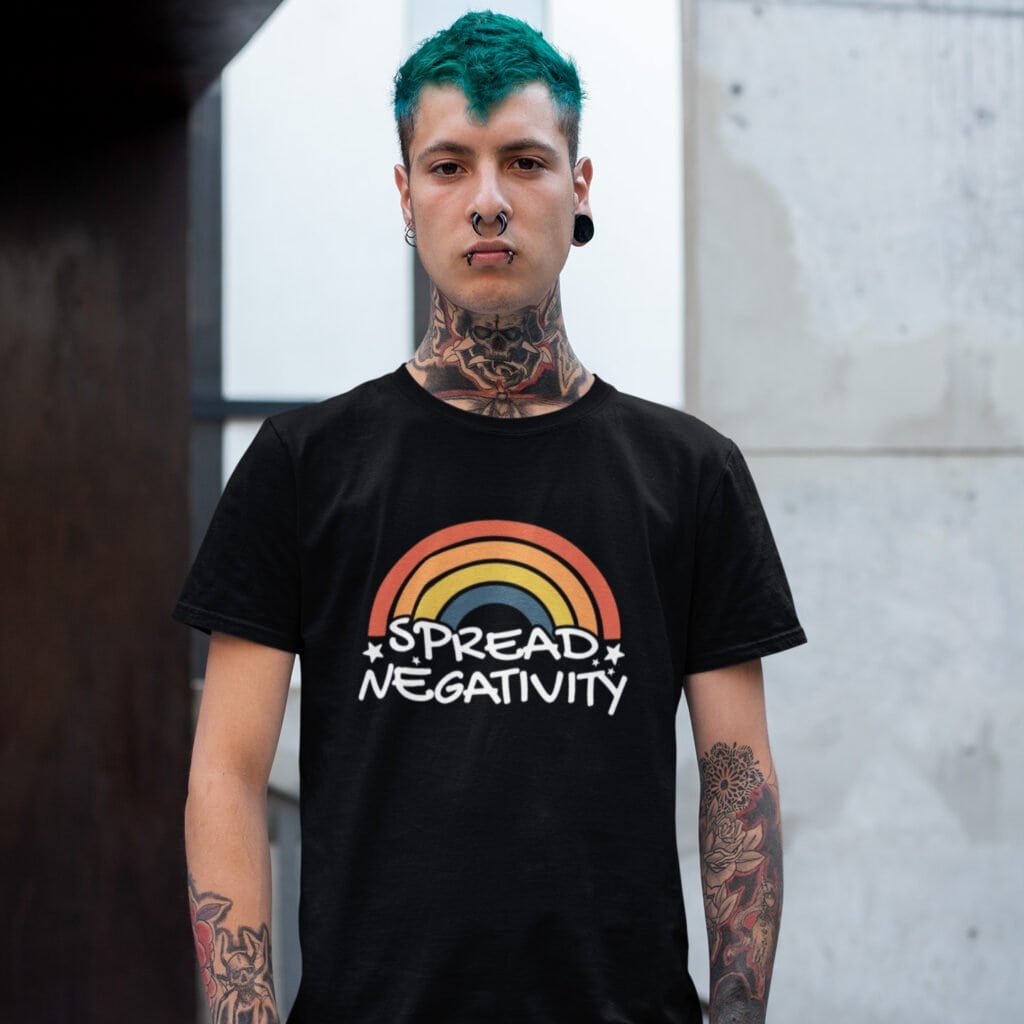 Man wearing a black t-shirt with a graphic of a rainbow and the words 'Spread negativity' printed on the front.