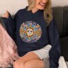 Smiling woman sitting on sofa wearing a navy blue hoodie sweatshirt with a sun graphic and the text 'Have an awful day' printed on the front.