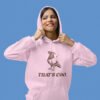 Woman wearing a light pink hoodie sweatshirt with an image of a pigeon and the words 'That's coo.' printed on the front.