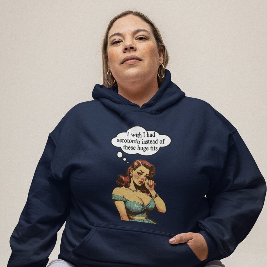 Woman wearing a navy blue hoodie sweatshirt with an image of a busty pin-up lady with thought bubble that says 'I wish I had serotonin instead of these huge tits' printed on the front.